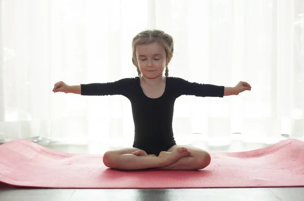 stock image Little girl doing gymnastic exercise. Girl doing yoga at home