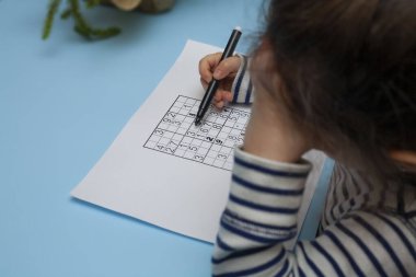 Çocuk Japon bulmaca sudokusu çözüyor