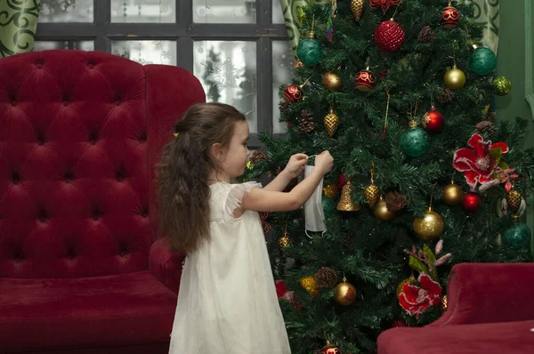 Bambina Decora Albero Natale Con Una Maschera Medica Anno Nuovo — Foto Stock