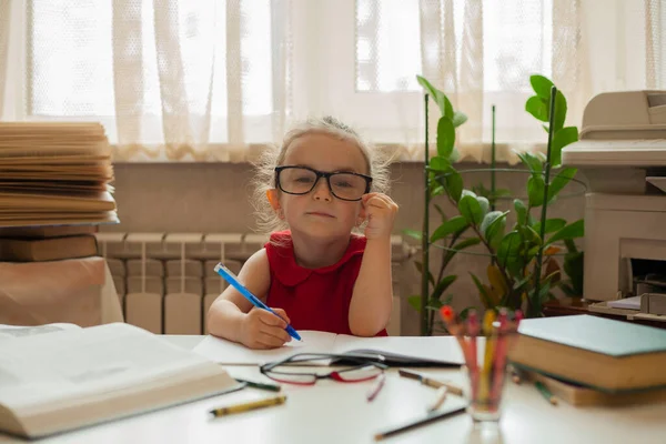 Little girl learns lessons. Knowledge day. Child in the office