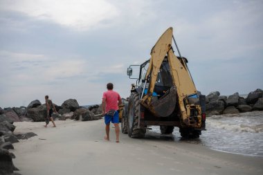 Traktörle sahili temizliyorum. İnsanlar plajı temizler. Tatilde temiz plaj.