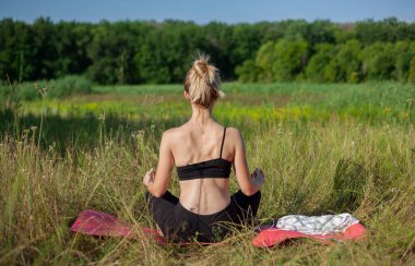 Yoga ve fitness. Genç bir kadın sahilde sabah meditasyonu yapıyor. Yoga. Spor. Siluet.