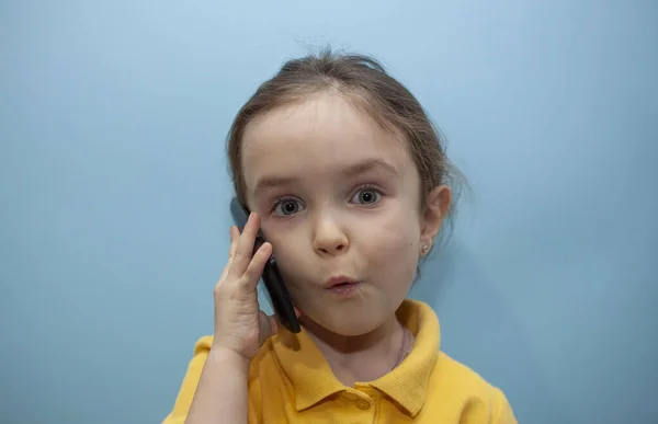 Kleines Mädchen Gelbem Shirt Auf Blauem Hintergrund Kind Telefoniert Und — Stockfoto