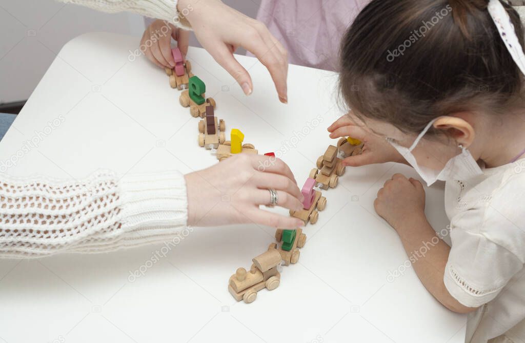 Two little girls in play constructs in the kindergarten. Little sisters play with a little train