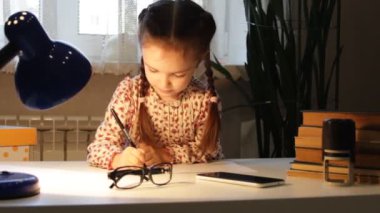 Küçük kız çiziyor. Çocuk bir sayfa kağıda notlar alır. Ofis işi.