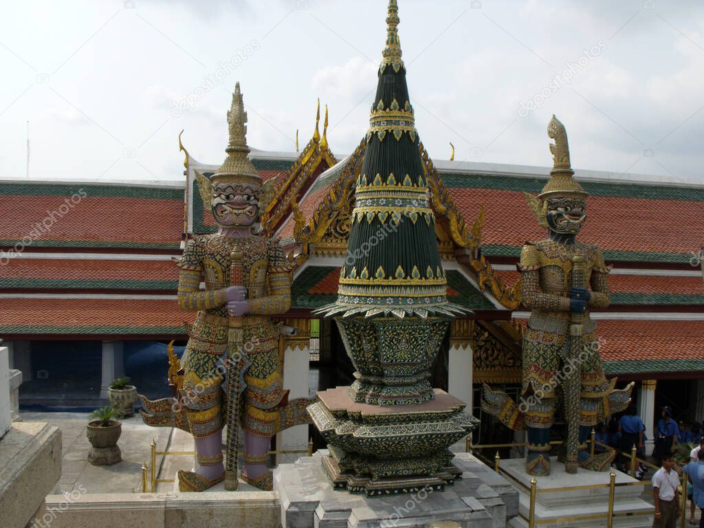 Bangkok, Thailand, January 25, 2013: Sculptures of two great mythological warriors next to a stupa of the Royal Palace in Bangkok