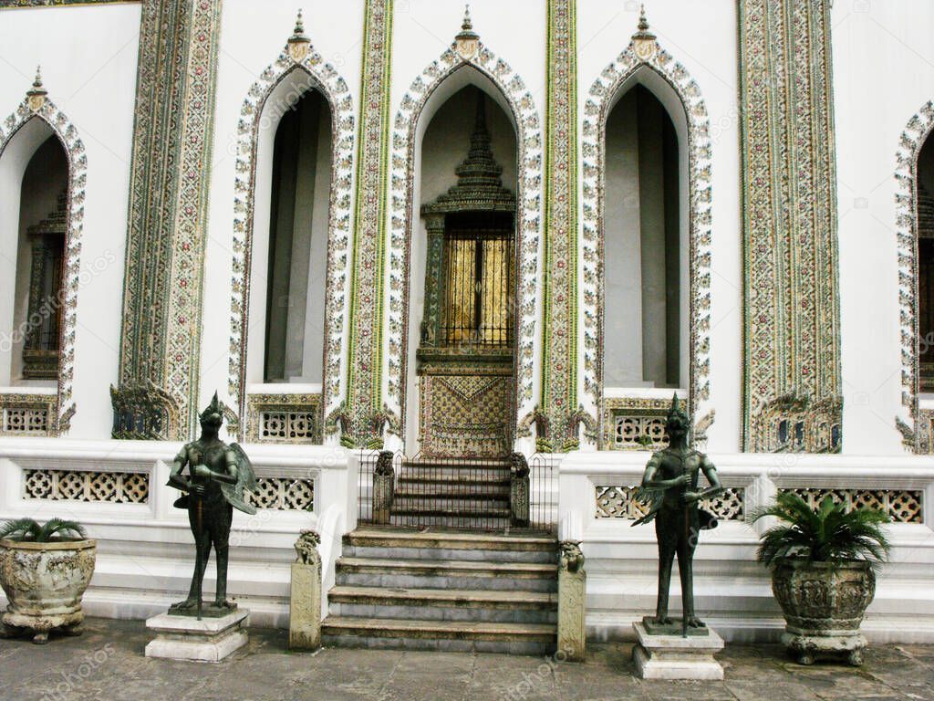 Bangkok, Thailand, January 25, 2013: Sculptures of two mythological warriors guard the entrance of a building in the Royal Palace in Bangkok