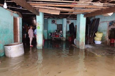 Hoi An, Vietnam, 29 Ekim 2020: Thu Bon nehrinin kıyısındaki sel basmış evinde bir kadın Tayfun Molave geçidinden taştı.