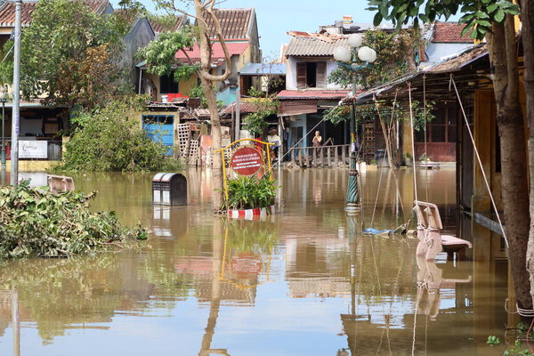 Hoi An, Vietnam, October 29, 2020: A woman in Hoi An looks from her house at the street flooded by the passage of Typhoon Molave