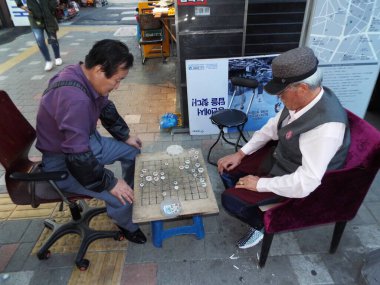 Seul, Güney Kore, 6 Ekim 2016: Namdaemun pazarındaki bir sokakta iki erkek masa oyunu oynuyor. Seul