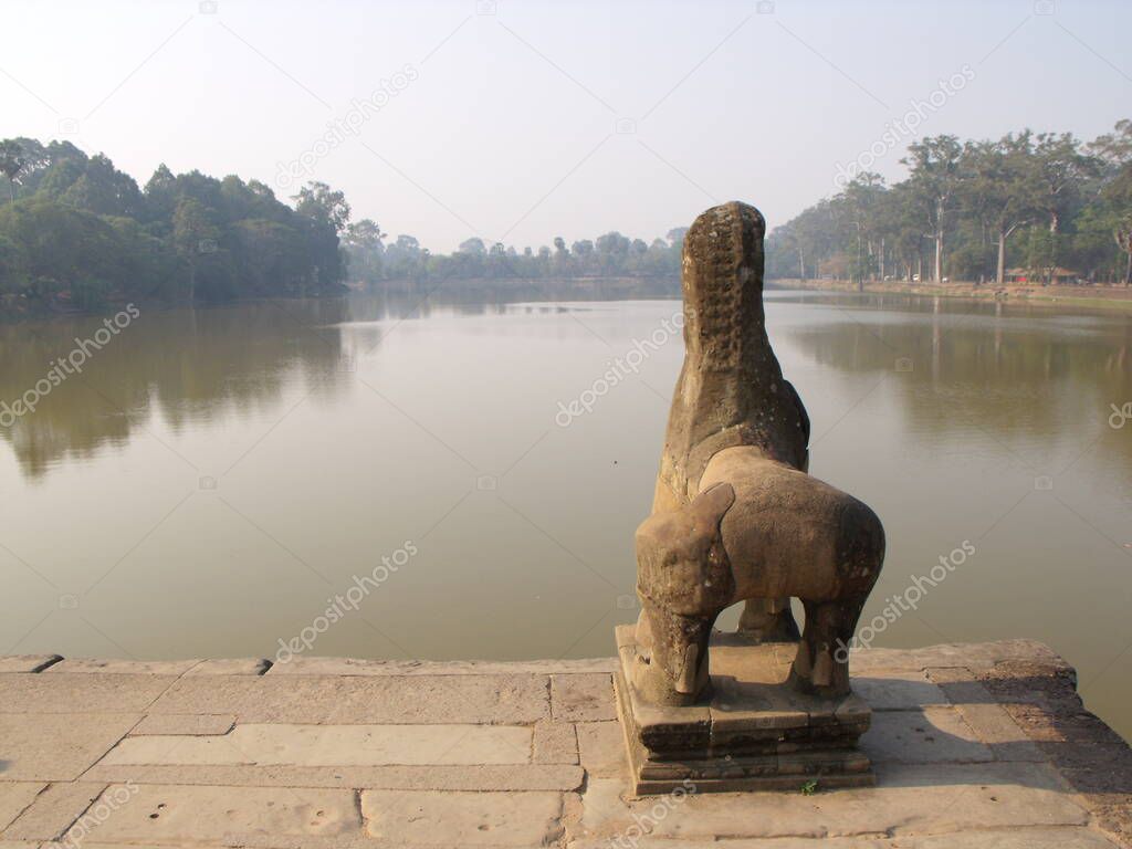 Siem Reap, Cambodia, April 6, 2016: Stone sculpture of a lion in front of a lake in the Khmer temple complex of Angkor