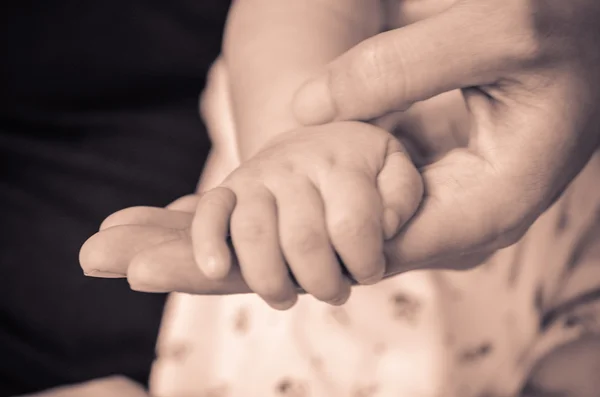 Baby hold her mother 's hand — стоковое фото