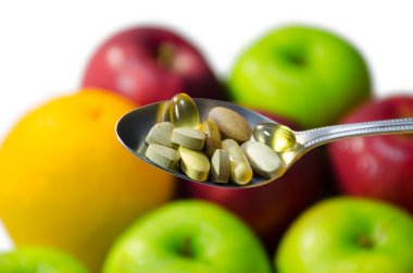 Assorted vitamins and nutritional supplements in serving spoon.  clipart