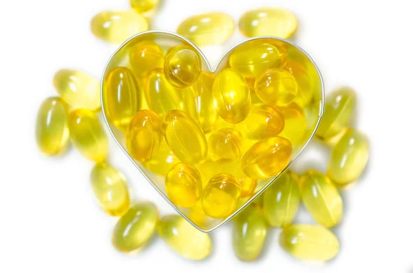 Pillole di olio di pesce su scatola a forma di cuore su sfondo bianco isolato — Foto Stock