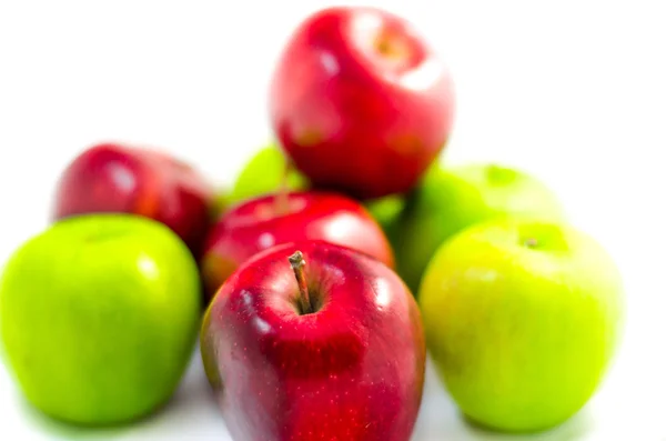 Manzana roja entre muchas manzanas verdes y rojas aisladas ba blanca — Foto de Stock