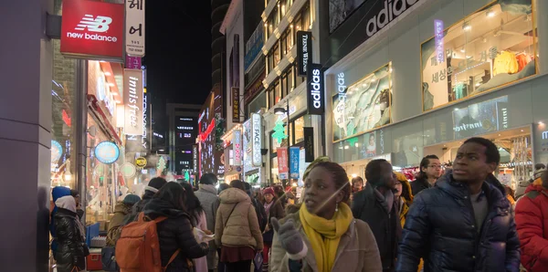 Escena urbana con multitud en la calle comercial por la noche en — Foto de Stock