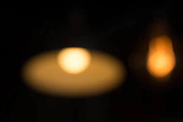 Desenfoque de la luz amarilla y naranja de la lámpara colgada — Foto de Stock