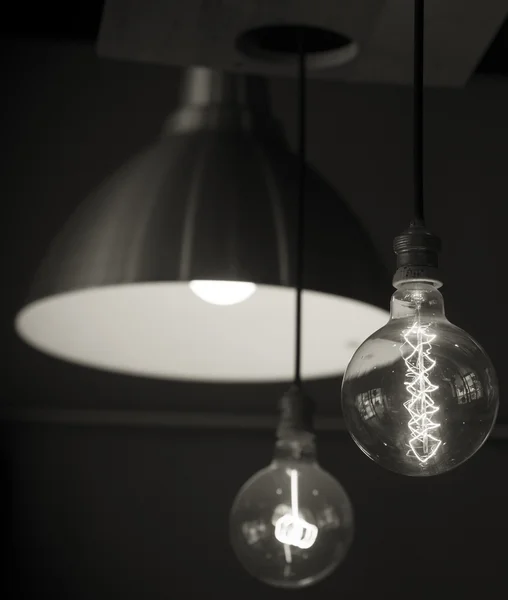 Ampul siyah ve beyaz üzerinde duruldu lambalar asıldı — Stok fotoğraf