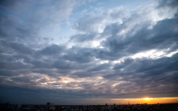 Puesta de sol con cielo nublado sobre la ciudad — Foto de Stock