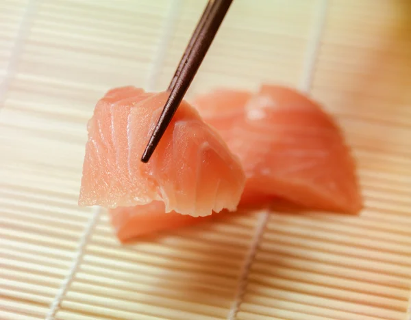 Кусочки сашими схвачены палочками для еды — стоковое фото