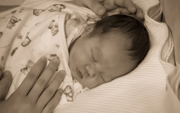 Asian female baby sleep on bed with mother put her  hand on the — Stock Photo, Image