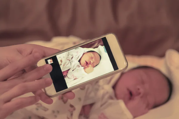 Mãe asiática tirar uma foto de seu bebê filho feminino com phon inteligente — Fotografia de Stock