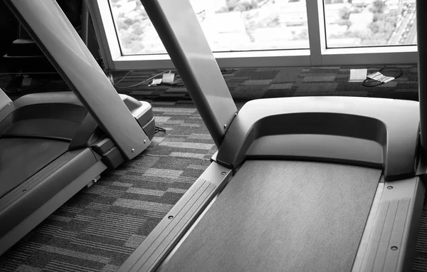 Loopbanden in fitness gym zwart-wit — Stockfoto