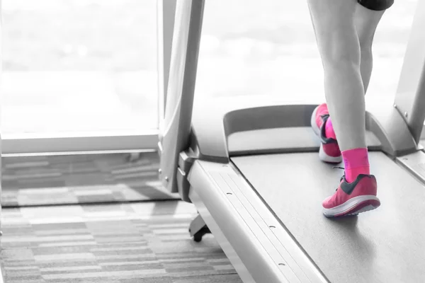 在跑步机上的粉红色鞋子的陌生的女人拆分粉红色吨 图库图片