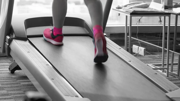 Mujer desconocida con zapatos rosados corriendo en cinta de correr dividida rosa bl — Foto de Stock