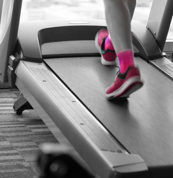 Woman with pink shoes running in treadmill in the gym 