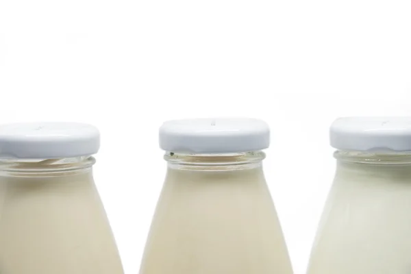 Üç süt şişelerini izole kapak üzerinde duruldu — Stok fotoğraf