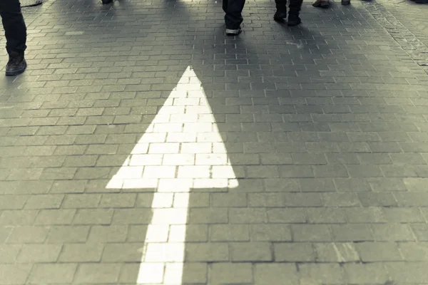 Flecha blanca recta en la calle peatonal con peo caminar Imagen de archivo