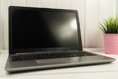 Oturma odasındaki ahşap masanın üzerinde boş ekran olan defter..