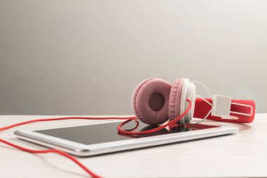 Masada beyaz tablet defteri olan kulaklıklar..