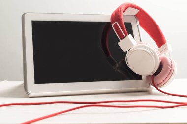 Masada beyaz tablet defteri olan kulaklıklar..