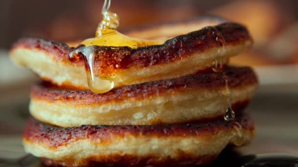 Pouring honey on light side of small pancakes — Stock Video