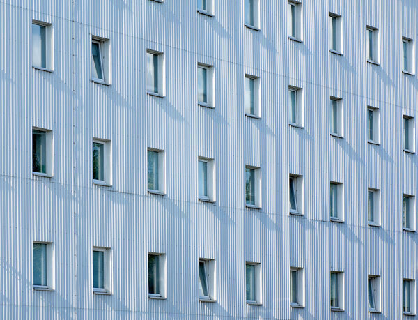 Modern architecture abstract geometric backgroung: building facade with alluminum panels as a siding and number of windows. Can be used as a wallpaper.