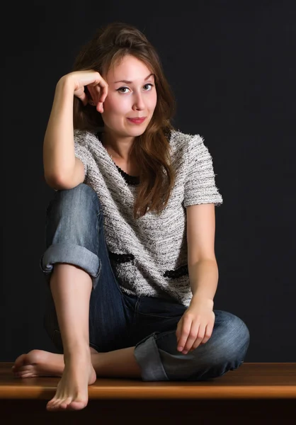 Yonug woman sitting cross-legged — Stock Photo, Image