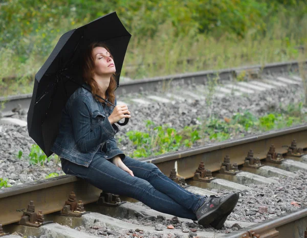 Dívka sedící deštník železnice — Stock fotografie