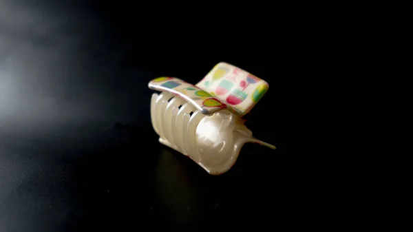 Beyaz büyük dişler. Plastik tutucu. Koyu arkaplanda saçı izole etmek için kullanılır.