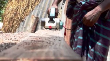 Bir marangoz odun kesiyor, odun işliyor.