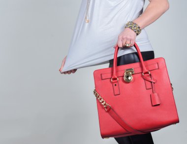 Saf arka plan üzerinde kırmızı şık çekici kadın deri çanta