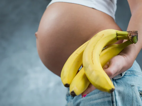 Primer plano de una linda barriga embarazada y comida saludable. fem embarazada —  Fotos de Stock