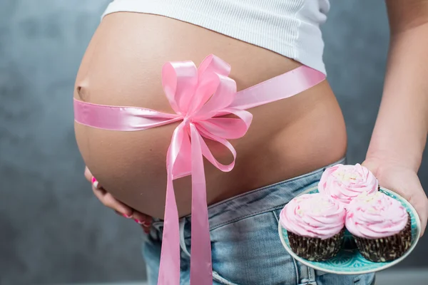Zbliżenie ładny brzuch w ciąży brzuch z różową wstążką i mar — Zdjęcie stockowe