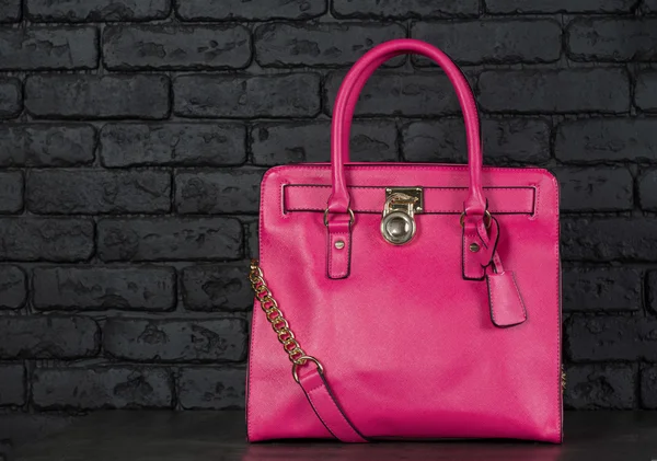 Rosa snygg kvinnlig läderväska isolerad på mörk bakgrund — Stockfoto