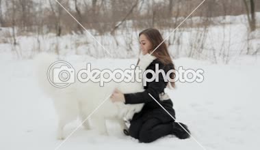 Genç kız ile bir köpek kış parkta oynarken. Yavaş motin