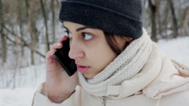 Güzel kız kış parkta bir smartphone cep telefonu ile konuşmak