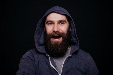Hoodies yakışıklı erkek sakallı, studio siyah arka plan vurdu.