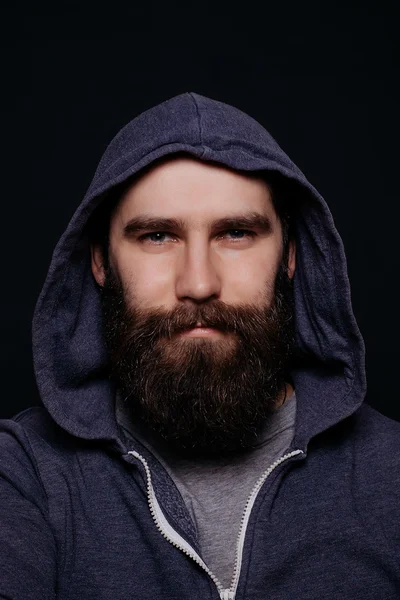 Guapo barba masculina en sudaderas con capucha, estudio de tiro fondo negro — Foto de Stock