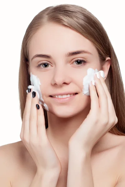 Mulher bonita limpeza rosto com tratamento de espuma luz de fundo — Fotografia de Stock